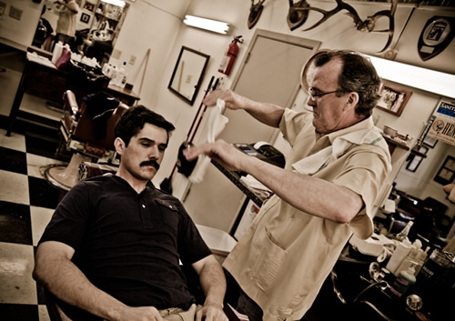 Barber pouring the warm towel.