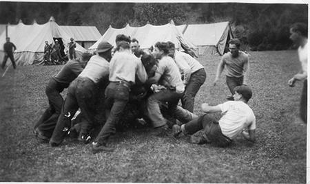 Vintage young boys playing rugby in open area.