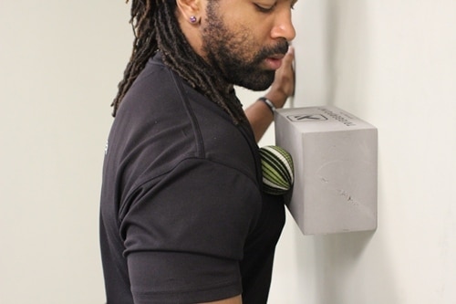 Vintage placing the yoga ball on the wall to get more pressure chest block wall.