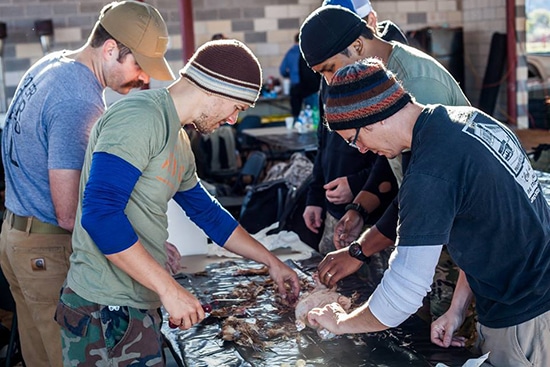 Plucking a Chicken Men Gathered around a Table.
