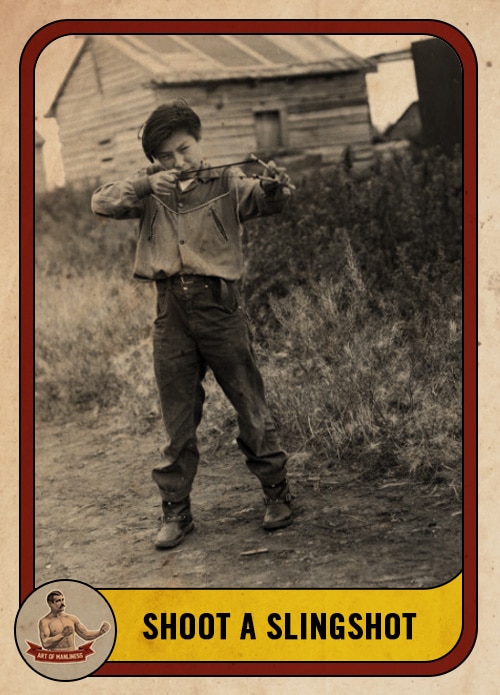 Vintage boy shooting a slingshot in a field.