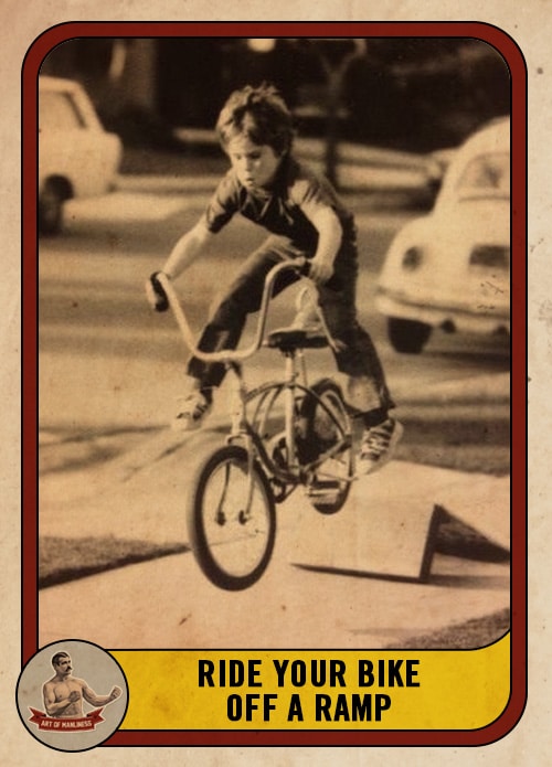 Vintage young boy riding jumping bike off a ramp.