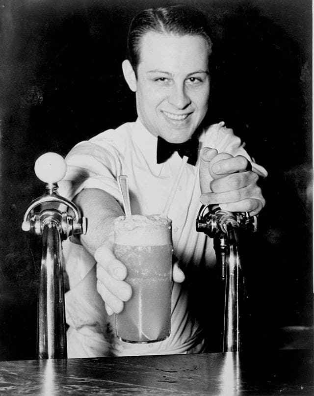 Vintage soda fountain worker pouring new York egg cream.