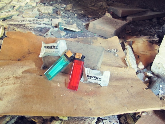 Burning fire by using lighters and fire starting tinder.