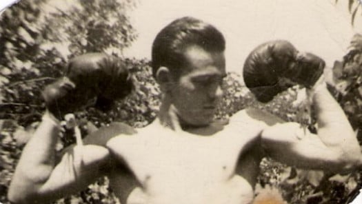 Vintage man wearing boxing gloves and showing biceps. 