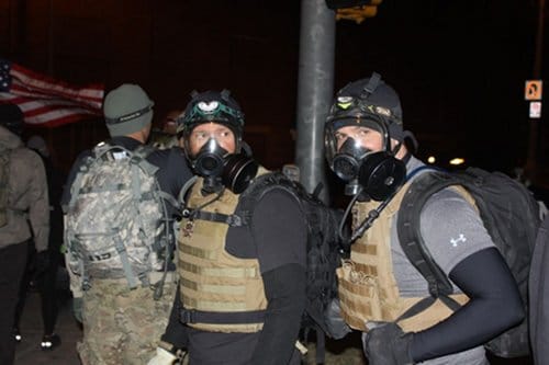 Guys from Blue Line Tactical Fitness wear gas masks.