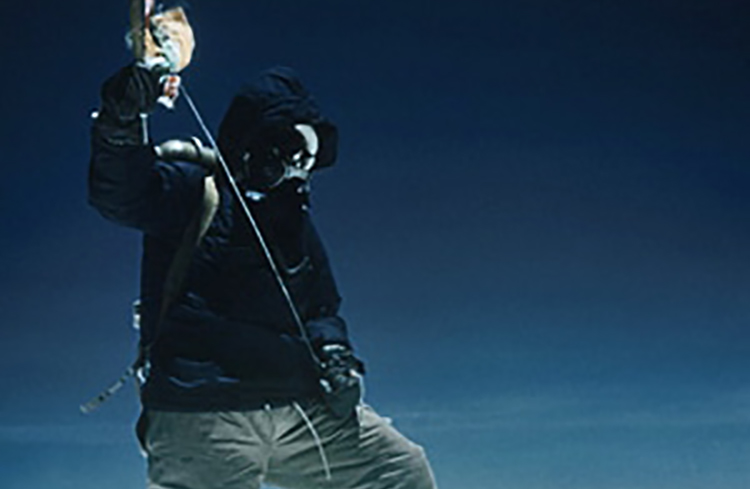 A man in a gas mask standing on top of a mountain, experiencing an adventure.