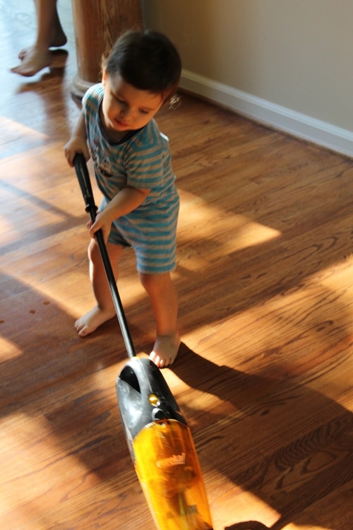 IMG_1058 Young boy doing chores vacuuming floor.