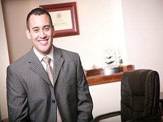 A financial planner in a suit standing in an office.