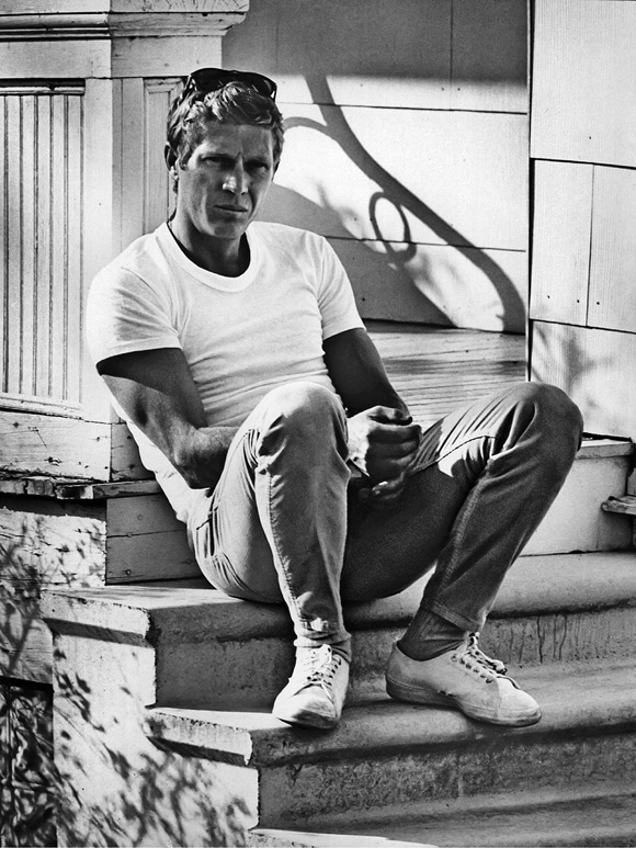 Steve mcqueen sitting on stairs.