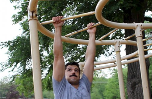 Vintage men doing monkey bars exercise.