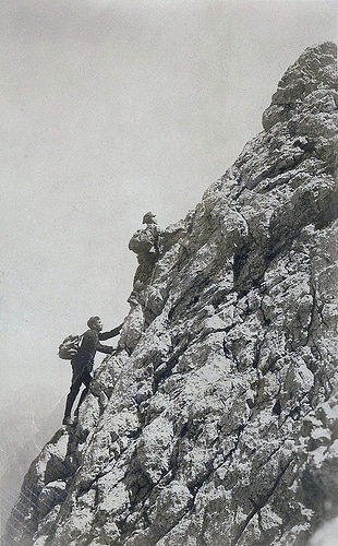 vintage mountain climbing Vintage mountain climbing men scaling rock.