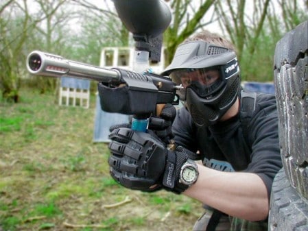 paintball Man playing paintball modern gun helmet equipment.