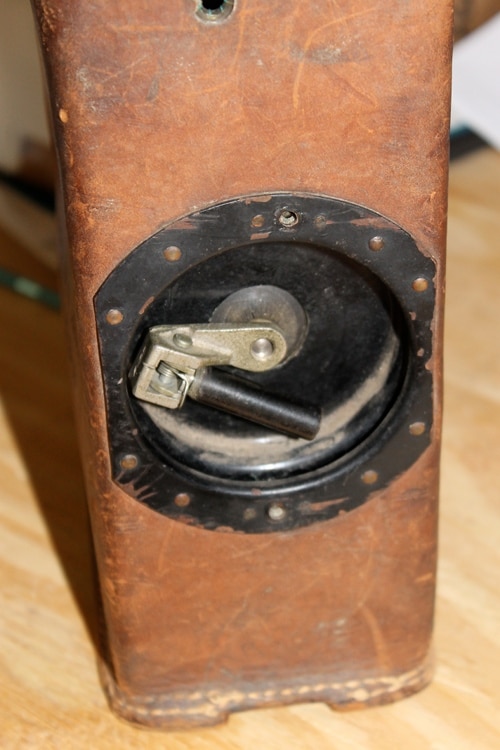 Vintage removing the screws from the crank handle on the side.