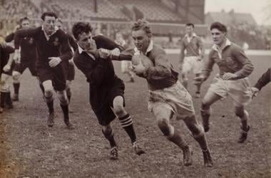 An old photo of a group of men playing rugby, showcasing the essence of fatherhood.