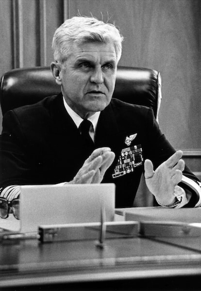 A man in a military uniform with medals is seated at a desk, gesturing with his hands while speaking about resilience and the Stockdale Paradox.