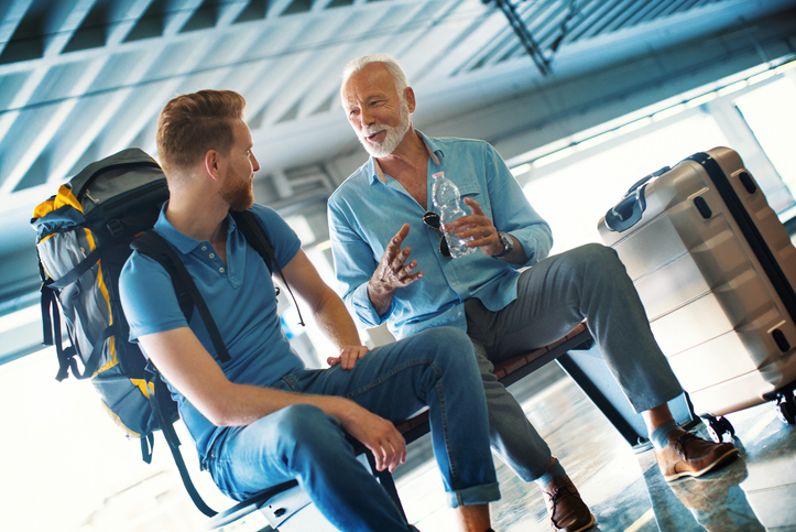 A man and a woman engage in conversation at an airport.