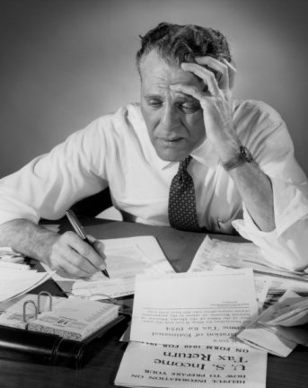 Vintage man looking stressed to see taxes papers. 