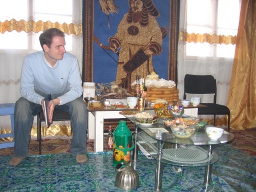 peace corps volunteer Travis Hellstrom sitting on chair carrying the handbook of The Unofficial Peace Corps Volunteer at Mongolia.