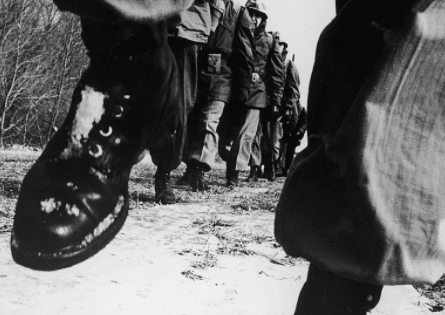 A group of soldiers participating in the JFK 50-Mile Challenge walk down a path.