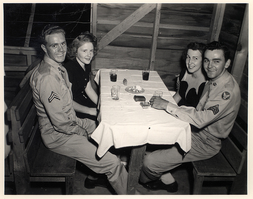 vintage double date dinner Vintage soldiers sitting with his wives at table.