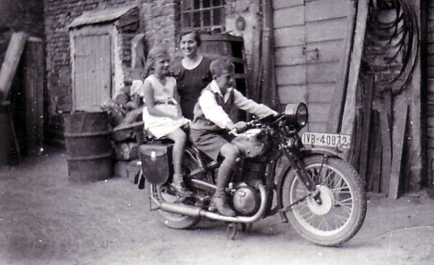 Vintage mom posing with children on motorcycle.